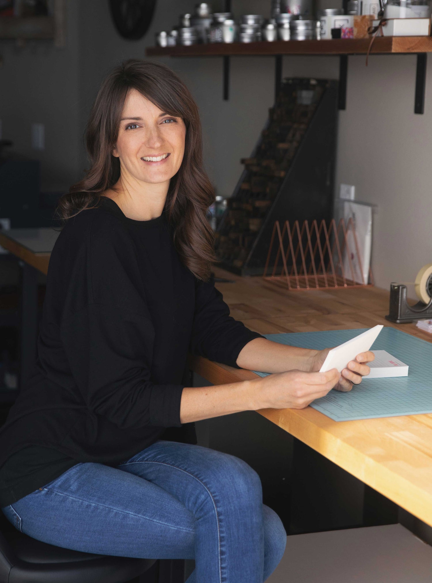 Letterpress printer in design studio, Bend, Oregon, holding custom letterpress stationery sets