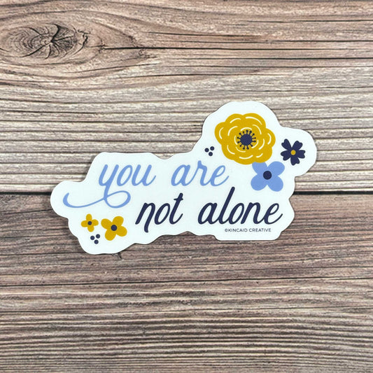 This You Are Not Alone waterproof floral sticker is a thoughtful reminder of support and connection. Perfect for water bottles, laptops, Kindles, or care packages. An ideal mental health encouragement sticker, or addition to a sticker set or pack.